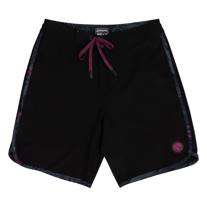 Waihana Pink Fishbone W1 board shorts laid flat, featuring a solid black body with dark floral side panel trim, burgundy drawstring, and a pink Waihana logo patch on the lower right leg.