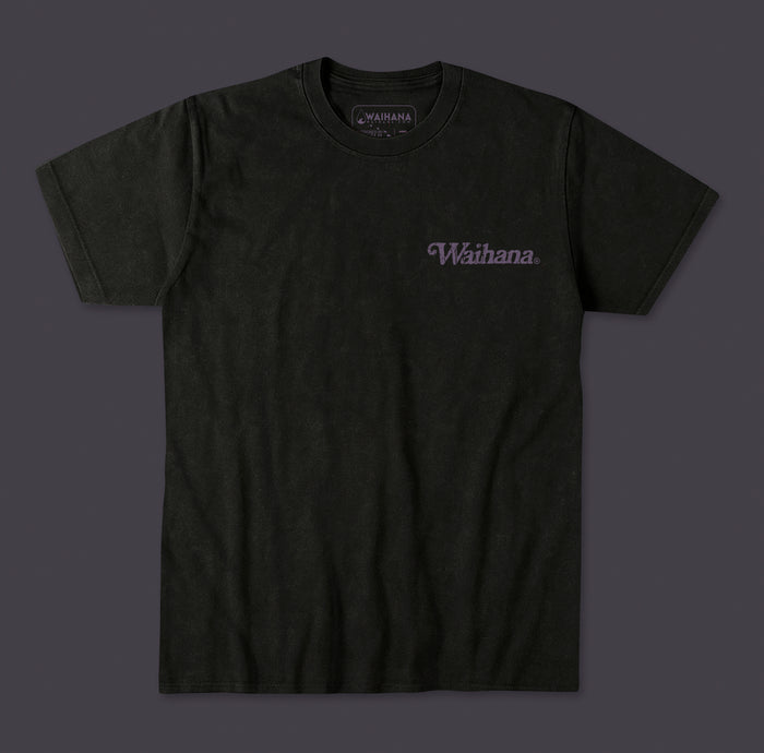 Waihana Purple Sands Premium Acid Washed Pima T-Shirt in Coastal Ash, a dark washed black tee with a tonal purple Waihana script logo on the left chest, displayed flat against a gray background.