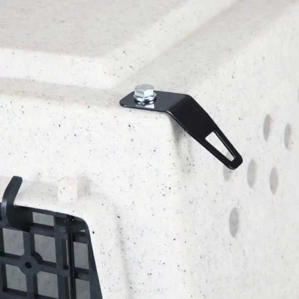 Black metal tie-down bracket bolted to the corner of a speckled white Ruff Land kennel for secure transport.