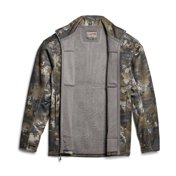Sitka Traverse camo jacket with an open front, showing a grey high-loft Berber fleece interior and mid-weight side panels.