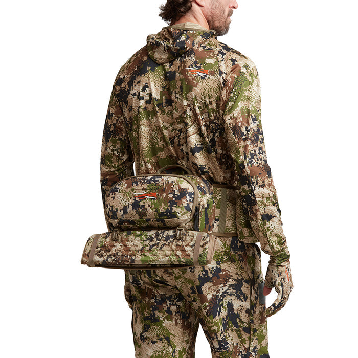 Hunter wearing a Sitka camouflage turkey hip pack with a removable padded seat and specialized call storage pockets.