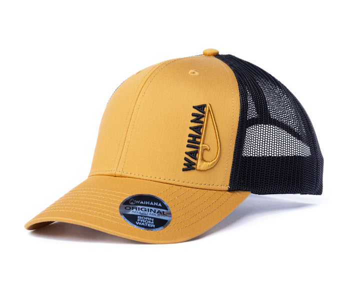 Waihana Sunset Beach Trucker hat in gold with black mesh back, featuring embroidered Waihana wordmark and fish hook logo on the front panel.