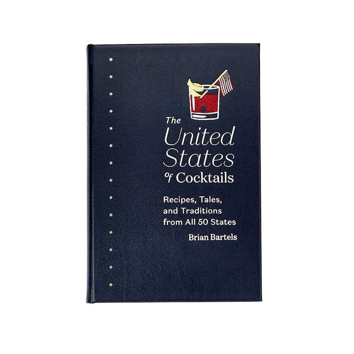 Navy blue bonded leather book titled The United States of Cocktails with a gold star spine and cocktail illustration.