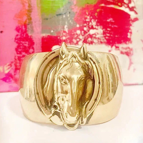 Adjustable brass cuff bracelet featuring an intricate vintage-style horse head and horseshoe design.