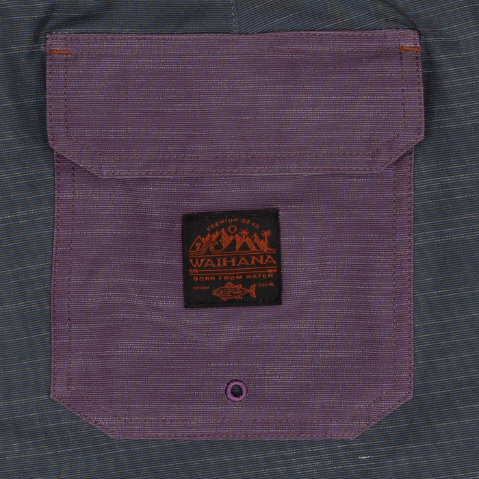 Close-up of a purple flap cargo pocket on Waihana Tidal Moss Cruiser Board Shorts with a woven Waihana 'Born From Water' brand patch.