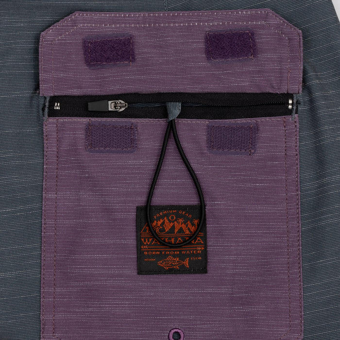 Close-up of the zippered back pocket with Velcro closure tabs and a Waihana branded woven label on the elastic zipper pull of the Tidal Moss Cruiser Board Shorts.