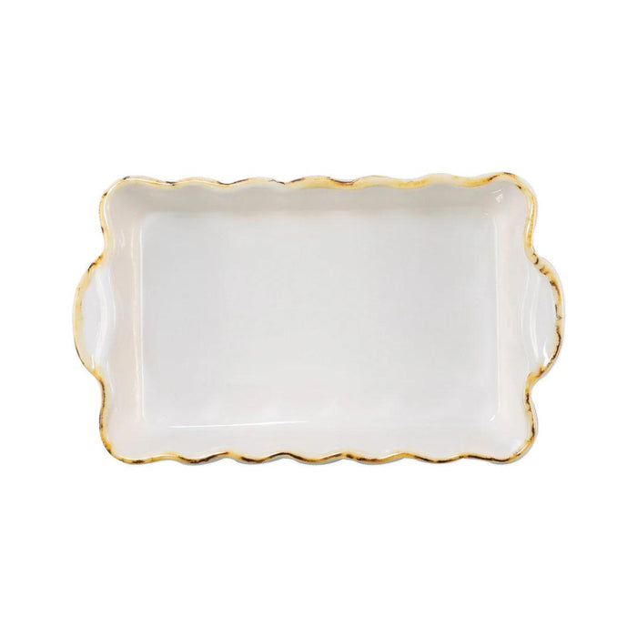 Small white rectangular Italian stoneware baker with scalloped edges and a rustic yellow trim.