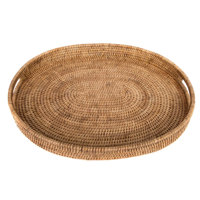 Handmade oval rattan ottoman tray in natural brown with integrated cutout handles on a white background.